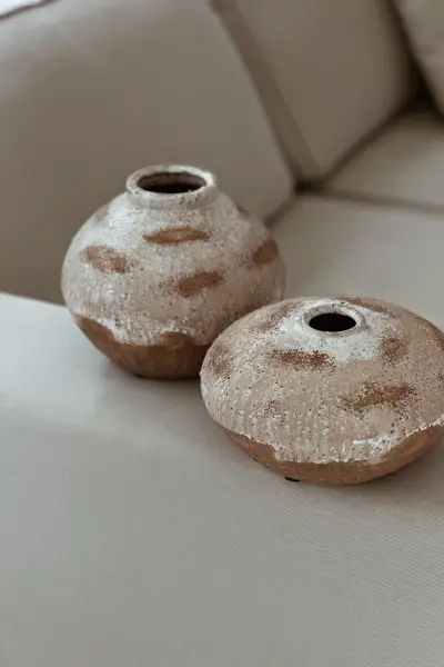 שני כלי חרס עגולים ומנוקדים על ספה בהירה